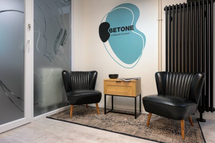 The waiting area: two black armchairs and a side table, with the Betone logo on the wall.